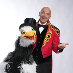 Ringmaster Wolf Fisher mit seinem Strauss – ein humorvolles Motiv mit einem seiner skurrilen komischen Freunde.